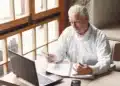 Homem idoso refletindo sobre suas finanças.