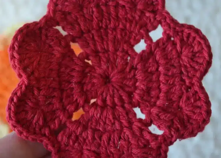 Porta-copos de crochê vermelho, com formato de flor, ideal para decorar a casa.
