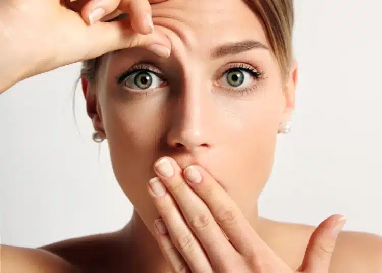 Mulher observando uma possível linha de expressão na testa, com foco nas mudanças na pele após os 40 anos.