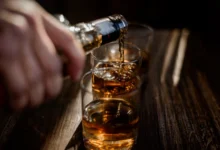 Imagem de copos de whisky sendo servidos, simbolizando os testes para detectar metanol em bebidas alcoólicas.
