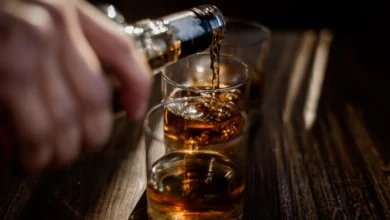Imagem de copos de whisky sendo servidos, simbolizando os testes para detectar metanol em bebidas alcoólicas.