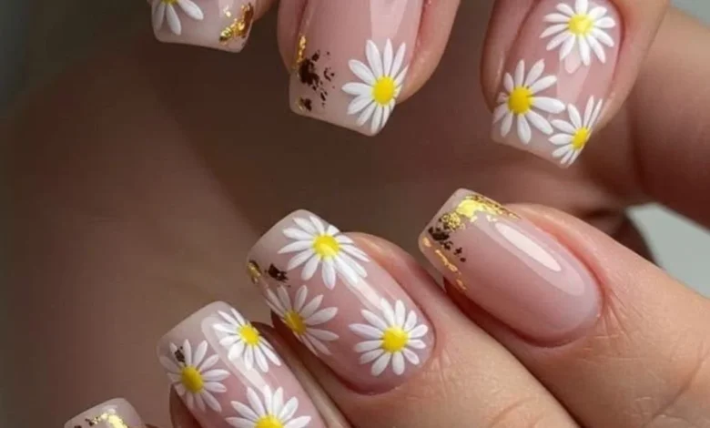 Unhas delicadas com flores brancas e amarelas, com detalhes em dourado, para a tendência de primavera de 2025.