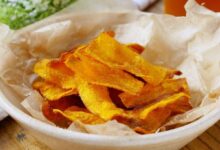 Chips crocantes de cenoura (ou batata-doce) em uma tigela, um exemplo de petisco delicioso e simples feito a partir do reaproveitamento criativo de sobras de vegetais.