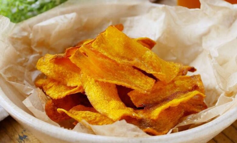 Chips crocantes de cenoura (ou batata-doce) em uma tigela, um exemplo de petisco delicioso e simples feito a partir do reaproveitamento criativo de sobras de vegetais.