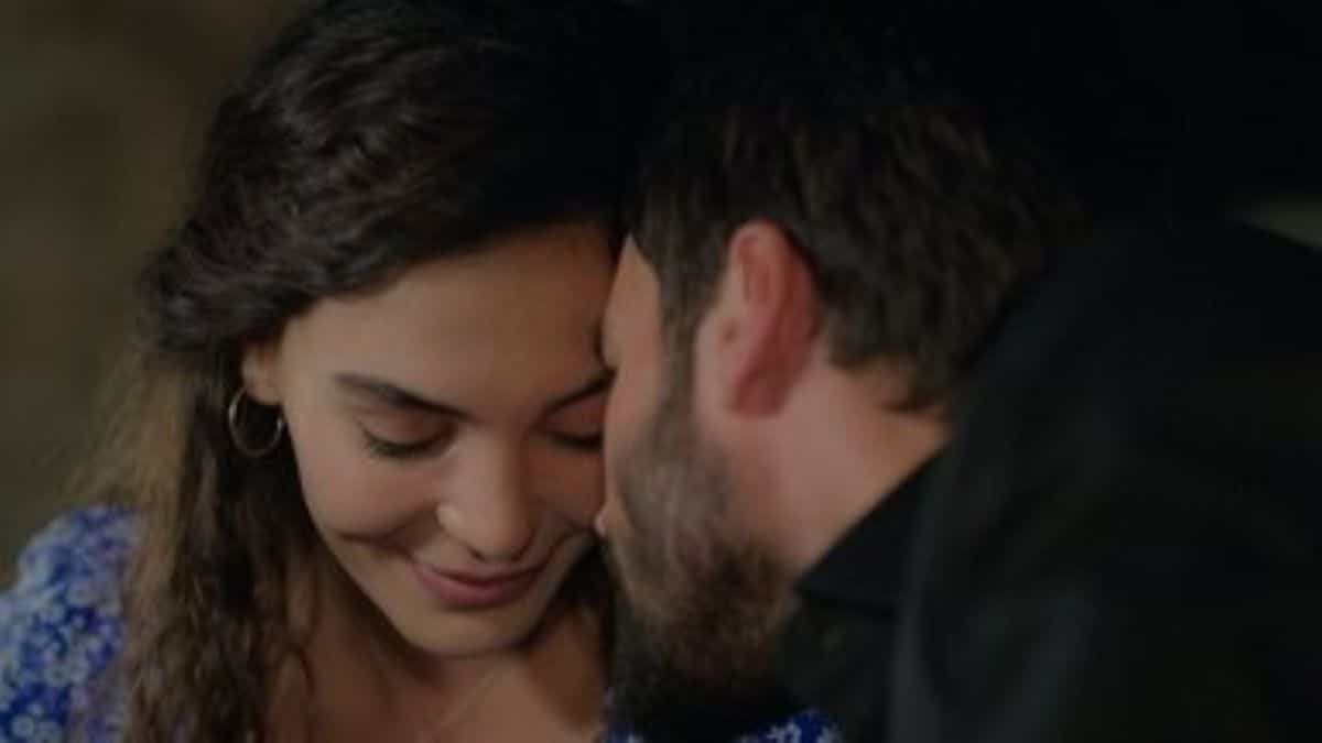 Um casal turco em um momento de ternura, o homem beijando a testa da mulher que sorri com os olhos fechados, ilustrando a paixão e os conflitos de 'Hercai: Amor e Vingança' no Globoplay.