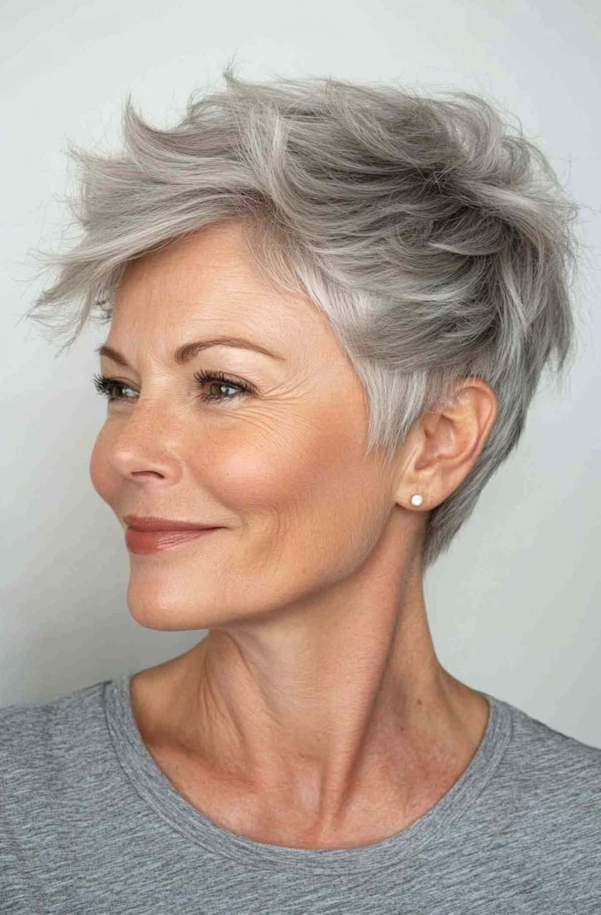 Mulher madura com cabelo grisalho e corte pixie moderno e despojado, simbolizando um visual jovem e prático.