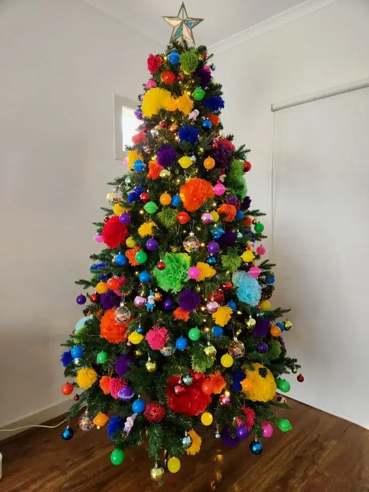 Árvore de Natal com bolas de diferentes estilos e cores. Árvore de Natal colorida com bolas e pompons vibrantes, criando uma decoração única e cheia de personalidade.