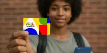 Imagem de um jovem segurando o cartão do Programa Bolsa Família, com um fundo de tijolos.