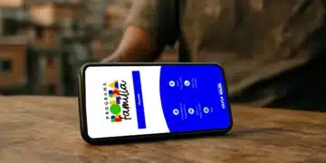 Aplicativo do Programa Bolsa Família exibido em celular sobre mesa, representando o acesso digital ao benefício.