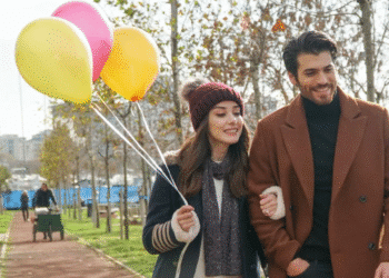 Casal feliz caminhando com balões coloridos em cena de novela turca, ideal para maratonar no Globoplay.
