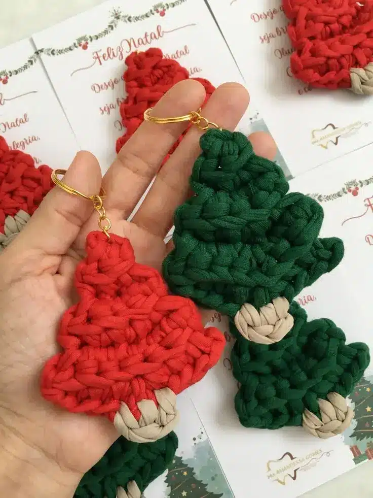 Chaveiros de árvore de Natal em crochê, com detalhes vermelhos e verdes.