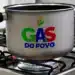 Panela no fogão com chama acesa exibindo o logo “Gás do Povo”, relacionado ao fim do Auxílio Gás e às novas regras do programa.