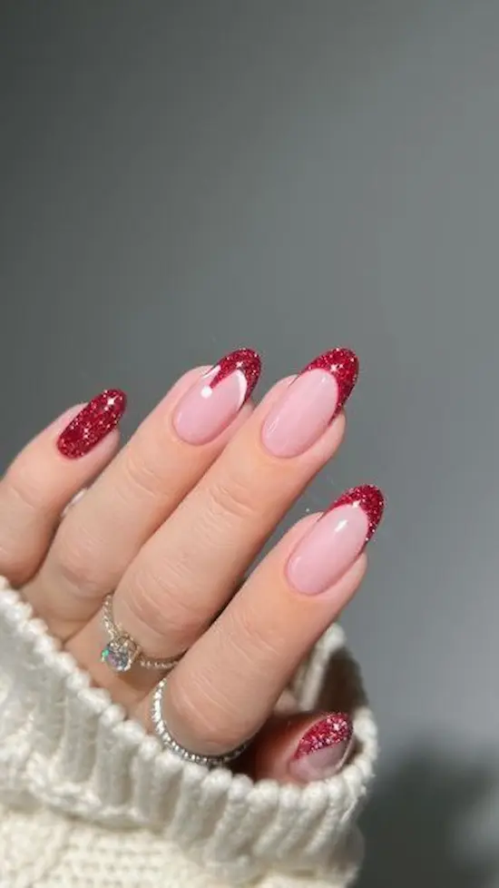 Unhas com francesinha vermelha e glitter, inspirado no gorro de Papai Noel moderno.