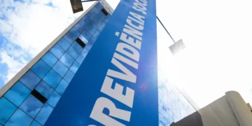 Fachada de prédio do INSS com placa azul sob céu claro.