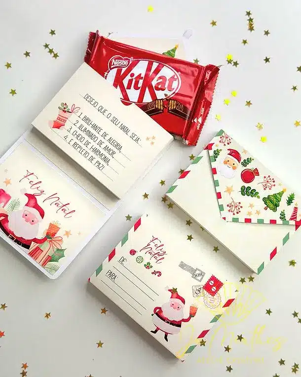 KitKat com mensagem personalizada de Natal, acompanhado de um cartão com ilustração de Papai Noel.