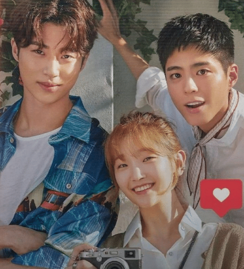 Dois homens e uma mulher sorrindo próximos, mulher segurando câmera fotográfica vintage