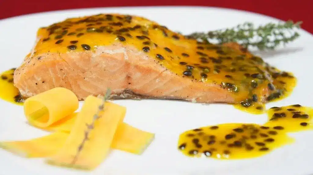 Salmão ao molho de maracujá Salmão grelhado coberto com molho de maracujá.