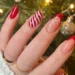 Unhas de Natal 2025 com detalhes vermelhos, dourados e design natalino, ideal para as festas de fim de ano.