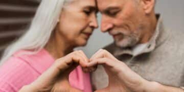 Casal idoso demonstrando carinho e formando um coração com as mãos