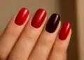 Unhas vermelhas em diferentes tons, incluindo vermelho vibrante e vinho, com acabamento brilhante e sofisticado.