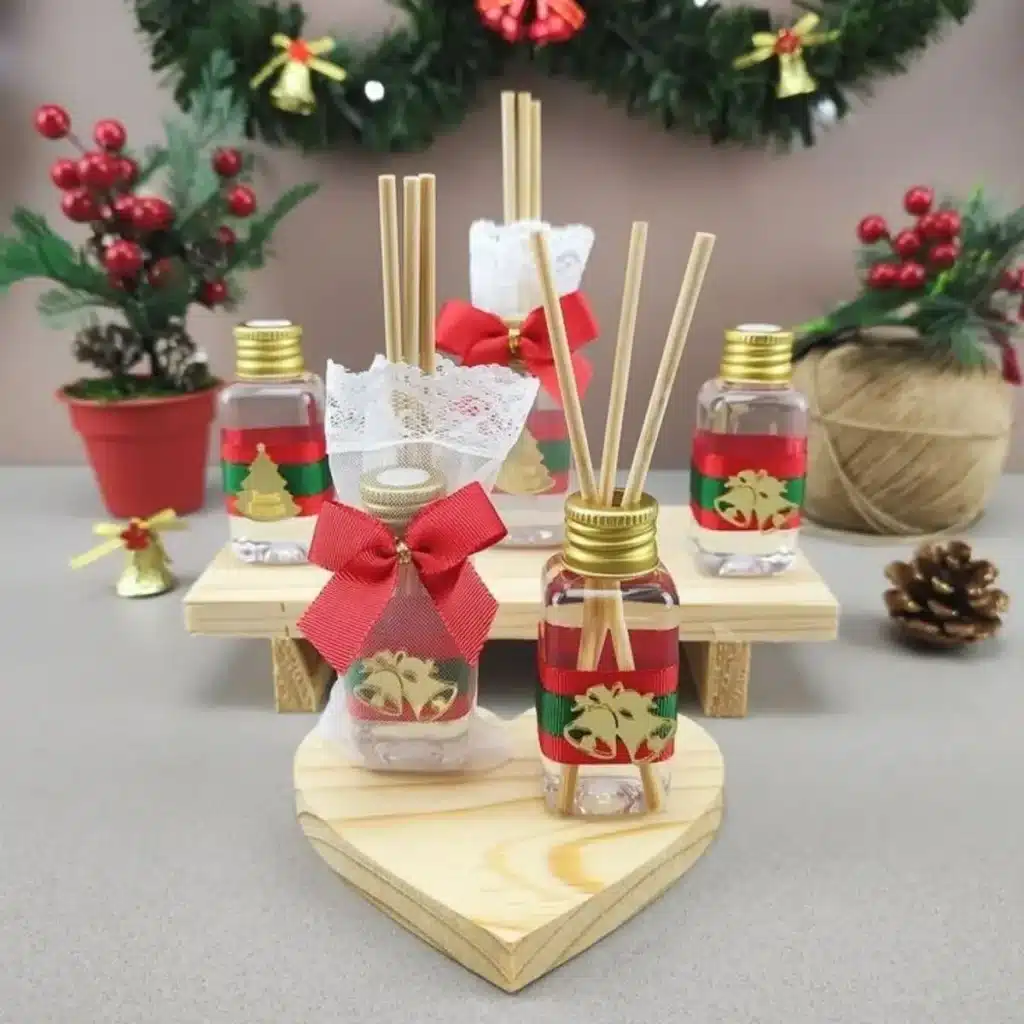 Mini aromatizadores de ambiente decorados para o Natal com laços vermelhos e dourados.