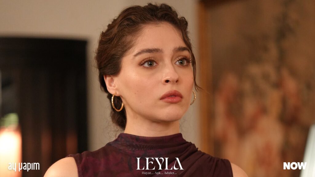 Leyla, personagem principal da novela turca 'Leyla: Sombras do Passado', com expressão pensativa, refletindo sobre seu passado e sua busca por vingança.