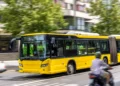 Ônibus amarelo em movimento representa o transporte público urbano usado no Passe Livre para idosos.