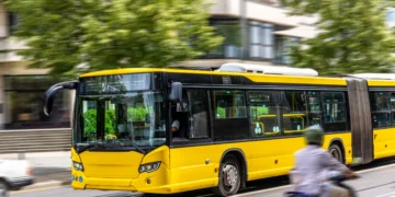 Ônibus amarelo em movimento representa o transporte público urbano usado no Passe Livre para idosos.