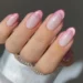 Unhas minimalistas em tom rosado com acabamento perolado e linhas delicadas na ponta.