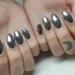 Unhas cromadas prateadas com acabamento espelhado, tendência de nail art para o Ano Novo.