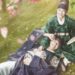 Casal de protagonistas do dorama Love in the Moonlight sorrindo em um campo de flores; a mulher veste trajes verdes de eunuco e o homem trajes reais azuis.