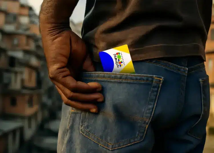 Cartão do Bolsa Família parcialmente visível no bolso de uma pessoa, representando suspensão dos pagamentos.