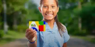 Criança sorrindo segura cartão do Bolsa Família enquanto governo anuncia data do primeiro pagamento de janeiro de 2026.