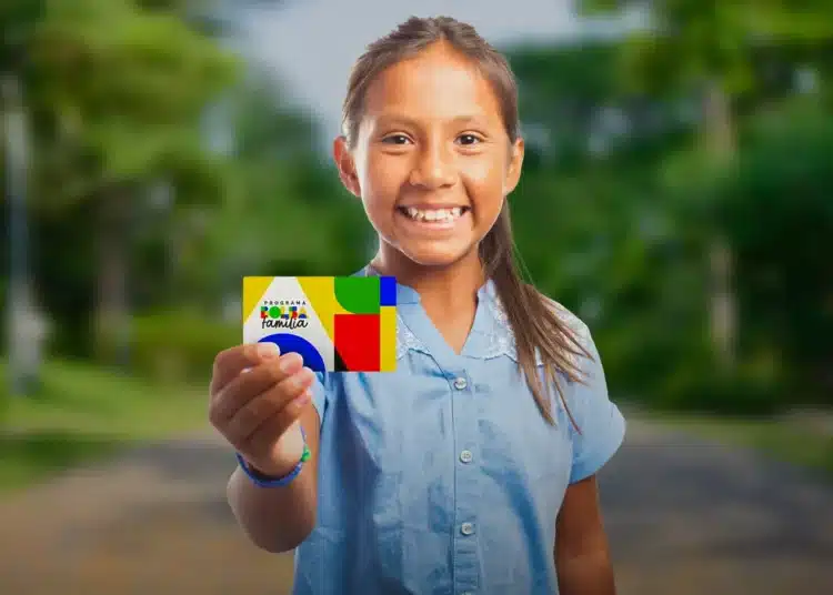 Criança sorrindo segura cartão do Bolsa Família enquanto governo anuncia data do primeiro pagamento de janeiro de 2026.