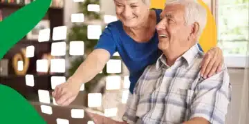 Casal de idosos felizes usando um laptop com orientação em ambiente doméstico