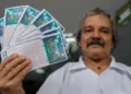 Homem segurando bilhetes da Mega da Virada, alertando sobre sites falsos que se passam pelas loterias da Caixa.