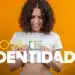 Mulher sorridente segurando nova carteira de identidade brasileira com fundo laranja
