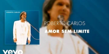 Roberto Carlos em performance ao vivo, com fundo azul e traje branco, representando o clima romântico da canção 'Amor Sem Limite'.