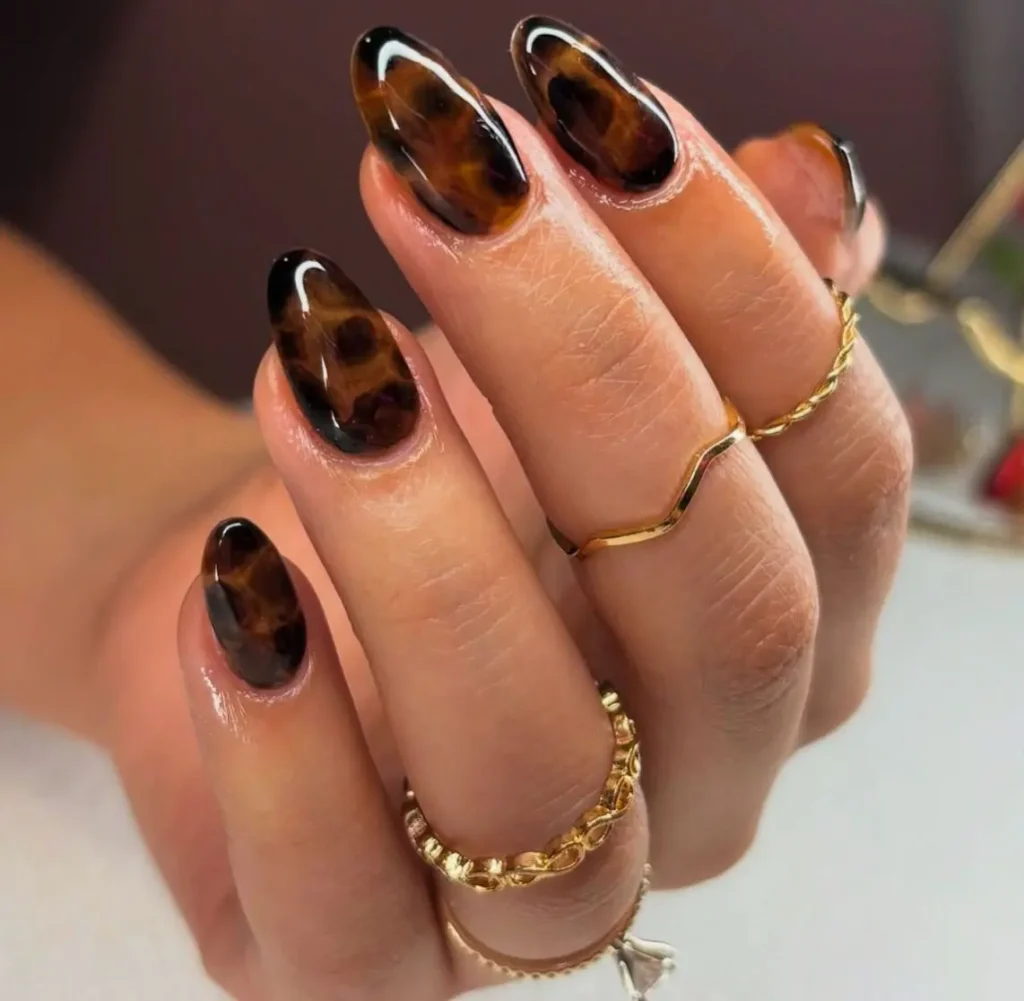 Tortoise Shell Nail Design Unhas com efeito casco de tartaruga, destacando a padronagem única e natural dos tons de âmbar, marrom e preto.