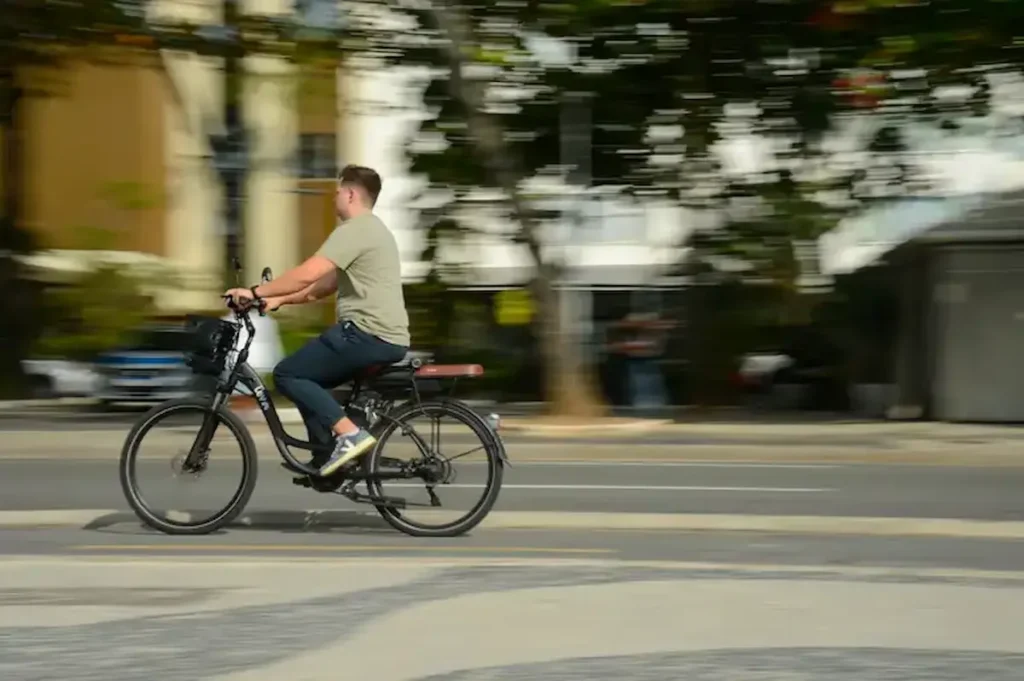 Bicicleta elétrica com acelerador agora é considerada ciclomotor Homem conduzindo bicicleta elétrica equipada com acelerador, destacando mudanças nas regras que a classificam como ciclomotor.