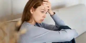 Mulher com expressão de preocupação, refletindo sobre o desgaste emocional e como fortalecê-lo com ferramentas psicológicas.