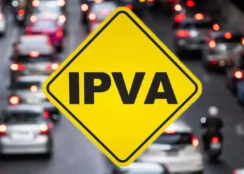 Sinal de trânsito com aviso de IPVA sobre fundo de trânsito, representando isenção para carros elétricos e híbridos em 2026.