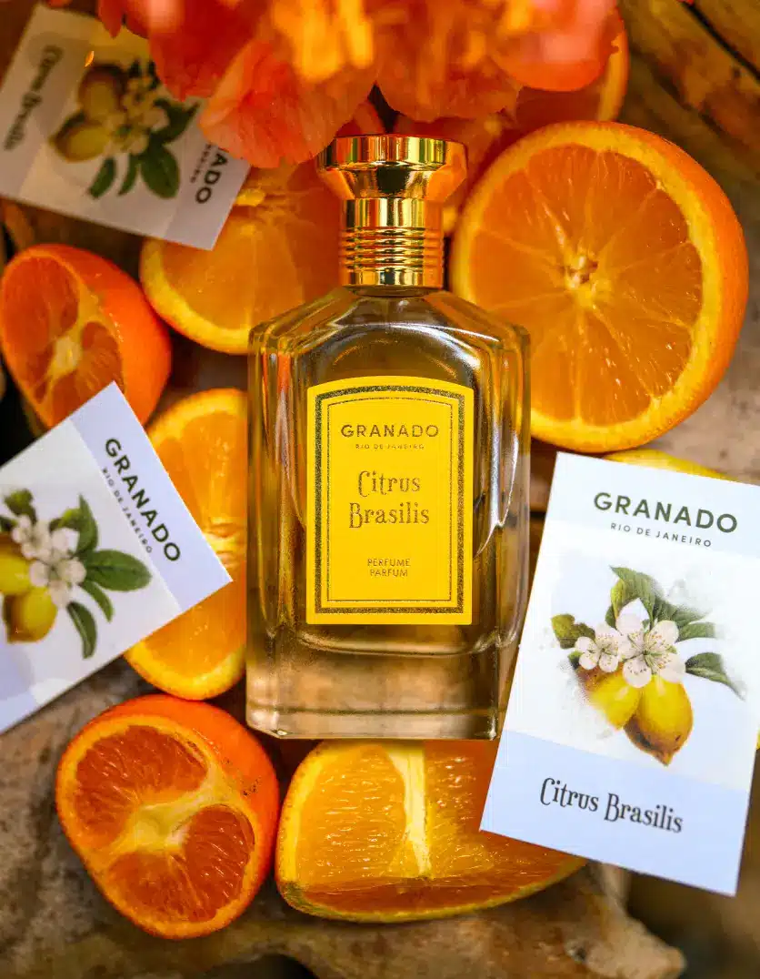 Citrus Brasilis Granado: Essência Vintage, Notas Cítricas e Versatilidade para o Verão Frasco de perfume Granado Citrus Brasilis rodeado por laranjas e flores cítricas, ilustrando a explosão de notas cítricas e o toque floral da fragrância.