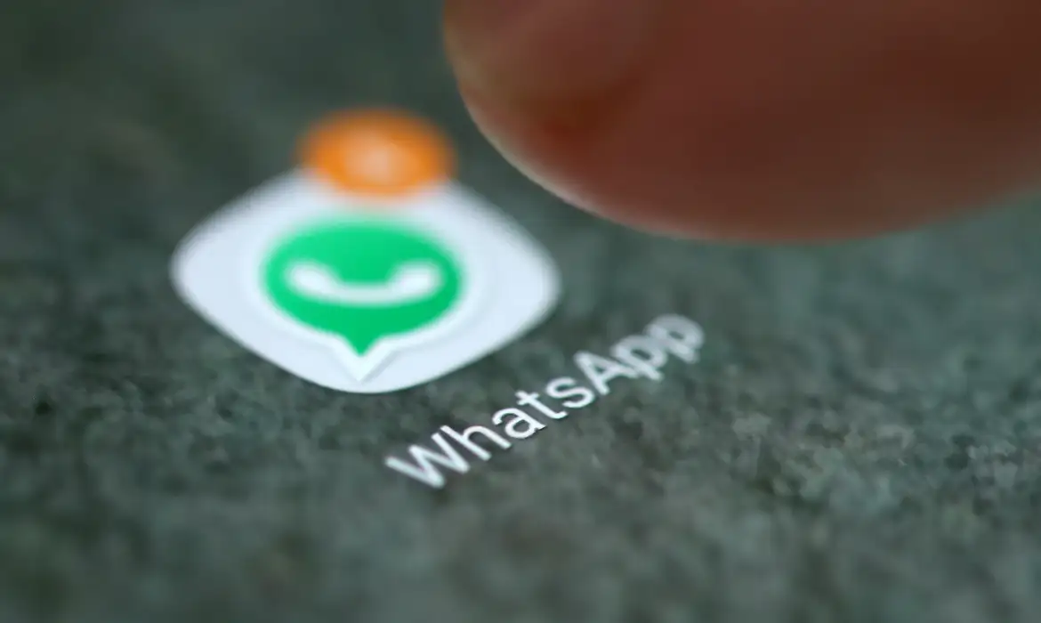 Ícone do WhatsApp com dedo tocando na tela Close no dedo tocando o ícone do aplicativo WhatsApp em um smartphone