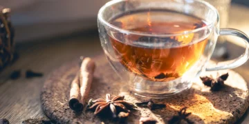 Xícara de chá quente com especiarias ao redor, representando bebidas naturais para controle de açúcar no sangue e redução da fome.