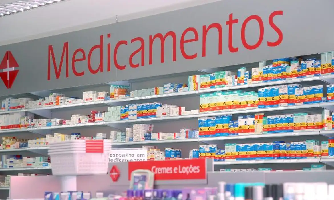 Seção de Medicamentos em Farmácia com Diversos Produtos Prateleiras organizadas com caixas de medicamentos em farmácia, com destaque para a placa "Medicamentos".