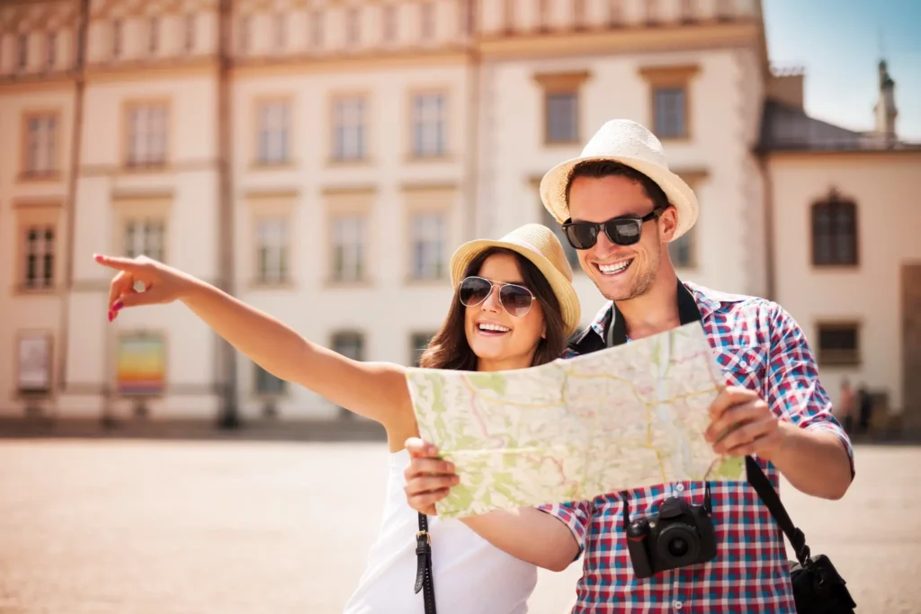 Turistas felizes explorando a cidade com mapa. Casal de turistas sorrindo e observando mapa enquanto exploram a cidade em um passeio.